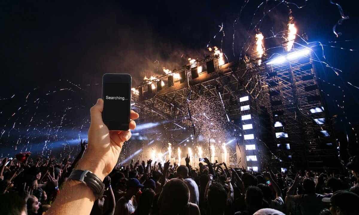 Una mano con cellulare che non riceve ad un concerto