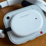 La cover esterna di Nothing Headphone (a) White in primo piano: il design semi-trasparente lascia intravedere la struttura interna, con il caratteristico accento rosso che firma l'identità Nothing. (mistergadget.tech)