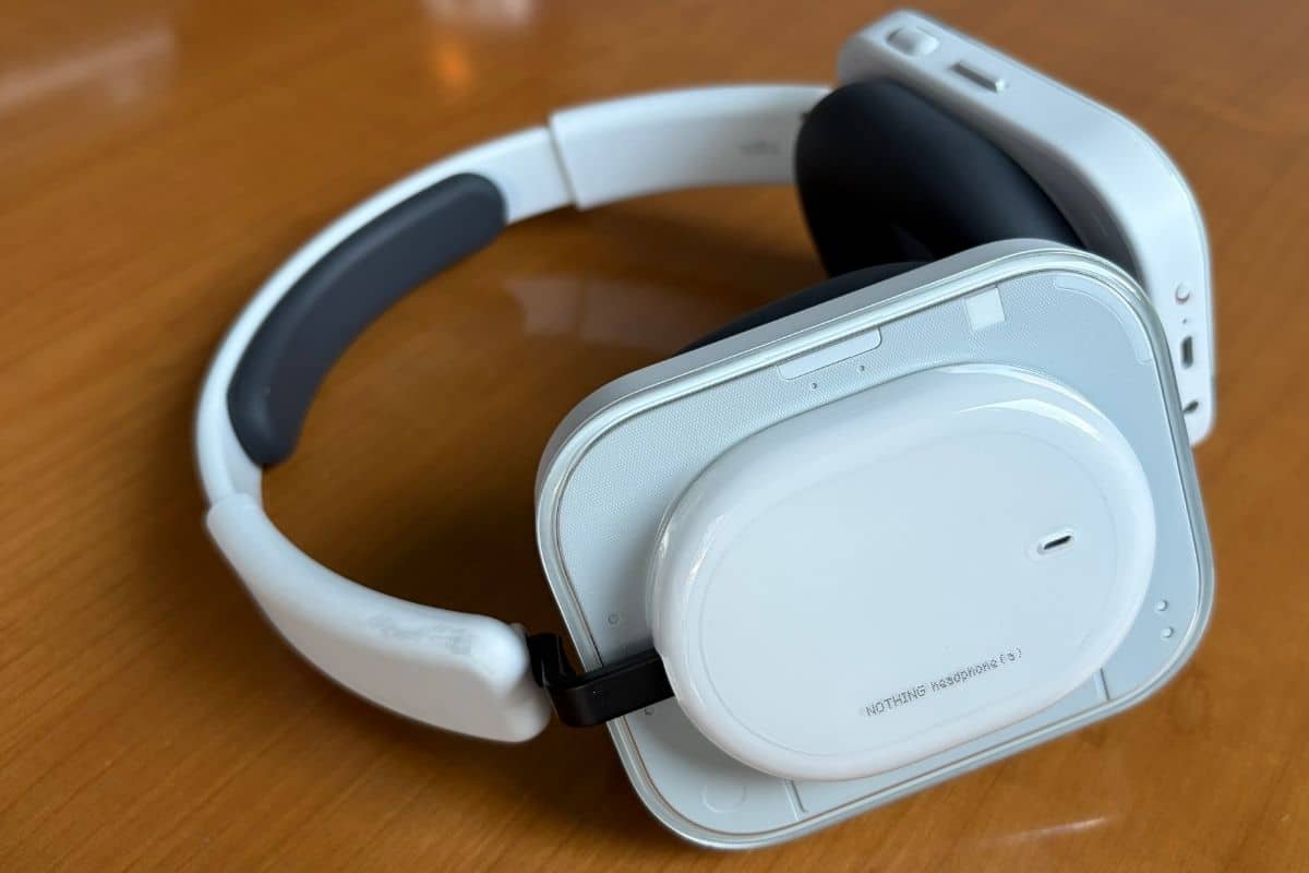 Nothing Headphone (a) White vista di tre quarti: il padiglione quadrato con angoli arrotondati e la finitura lucida del cap centrale sono gli elementi più riconoscibili del design. (mistergadget.tech)