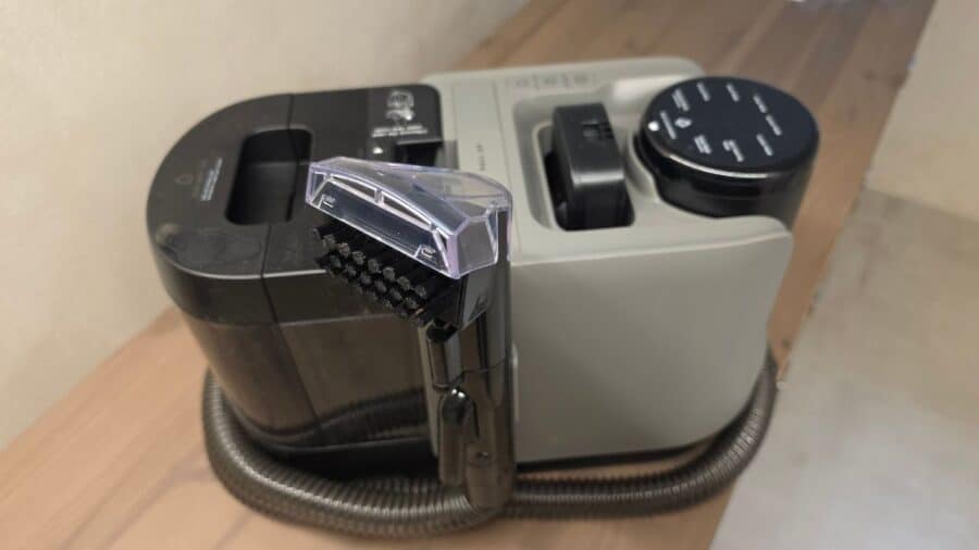 Vista frontale ravvicinata del modulo lavatappeti Dreame H15 Mix con bocchetta trasparente a spazzole nere montata sul tubo flessibile grigio scuro