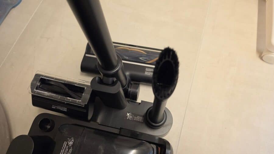 Vista dall'alto della testina aspirapolvere del Dreame H15 Mix: si vede il rullo brushless con copertura trasparente, il connettore centrale dell'asta e il bocchettone laterale circolare con spazzola nera per superfici specifiche