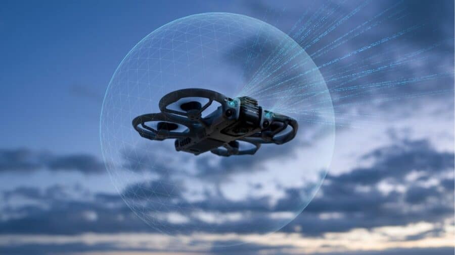 DJI Avata 360 in volo con grafica della sfera di rilevamento a 360 gradi che circonda il drone su sfondo cielo nuvoloso