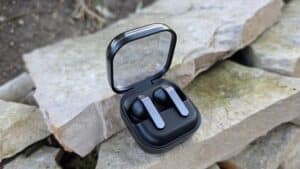 Samsung Galaxy Buds 4 Pro nella custodia aperta con coperchio trasparente su sfondo di pietra