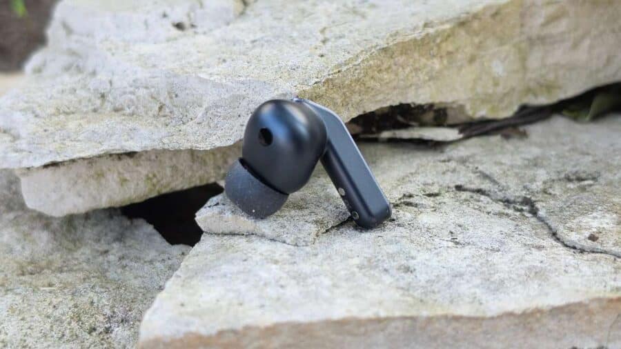 Samsung Galaxy Buds 4 Pro nero su pietre, vista laterale con terminale in silicone e gambo metallico