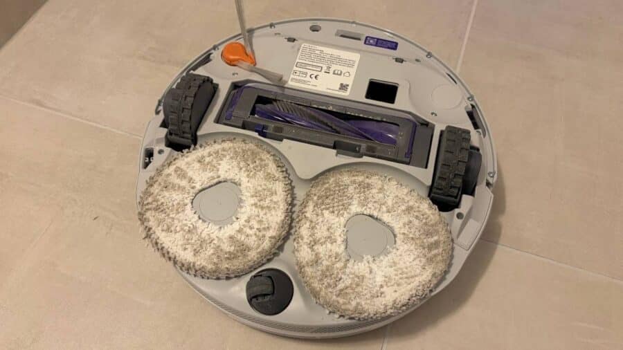 Parte inferiore del Narwal Freo Z10 Pro con i due moci Reuleaux sporchi di polvere e detriti dopo l'uso, rullo principale visibile al centro