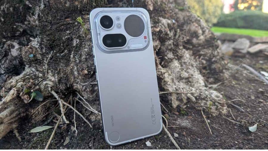 Nothing Phone (4a) Pro in colorazione Silver appoggiato verticalmente su una radice d'albero, vista del pannello posteriore in alluminio aerospaziale