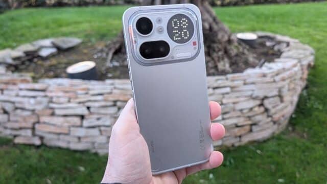 Nothing Phone (4a) Pro colorazione Silver tenuto in mano con il Glyph Matrix acceso che visualizza l'orario 08:20