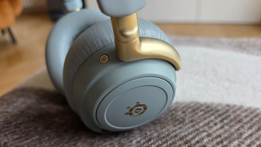 SteelSeries Arctis Nova Elite padiglione sinistro con microfono beamforming e dettaglio archetto dorato