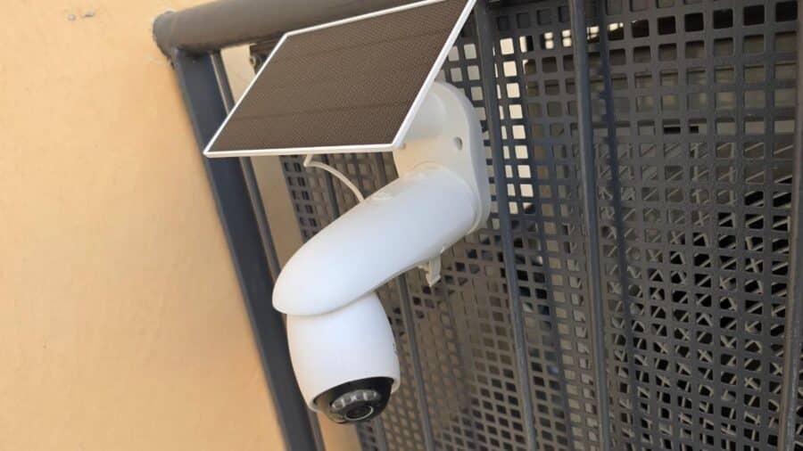 Tapo C660 Kit installata su cancello metallico con pannello solare Tapo A201 orientato verso l'alto, vista frontale completa