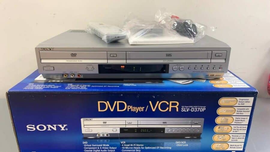 Un lettore Sony DVD e VHS combinato appoggiato sopra la sua scatola originale, con telecomando e accessori inclusi.