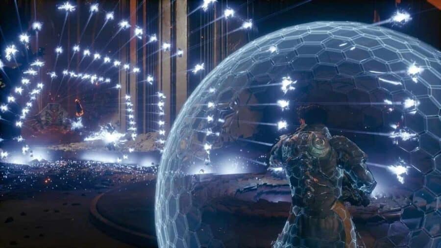 Il protagonista di Saros si protegge dietro uno scudo energetico semisferico mentre una tempesta di proiettili illumina l’arena sci-fi.