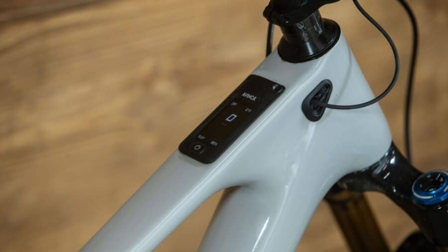 Primo piano del tubo orizzontale di una e-bike Amflow con display OLED integrato che mostra dati di sistema e livello batteria.