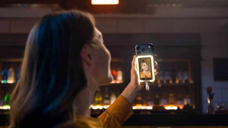 Una donna registra un selfie video in un ambiente interno poco illuminato usando Insta360 Snap con luce anulare integrata.