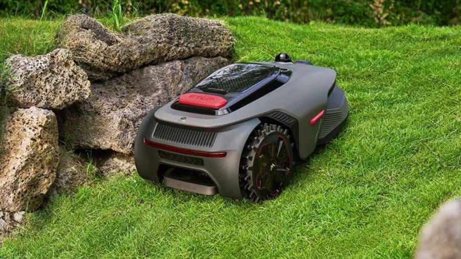 Il MOVA LiDAX Ultra 800 è parcheggiato vicino a grandi rocce decorative sul prato di un giardino residenziale.