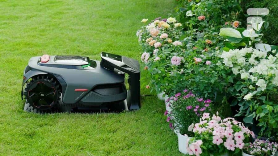 Il MOVA LiDAX Ultra 800 si muove accanto a un’aiuola ricca di fiori e piante ornamentali in un giardino curato.