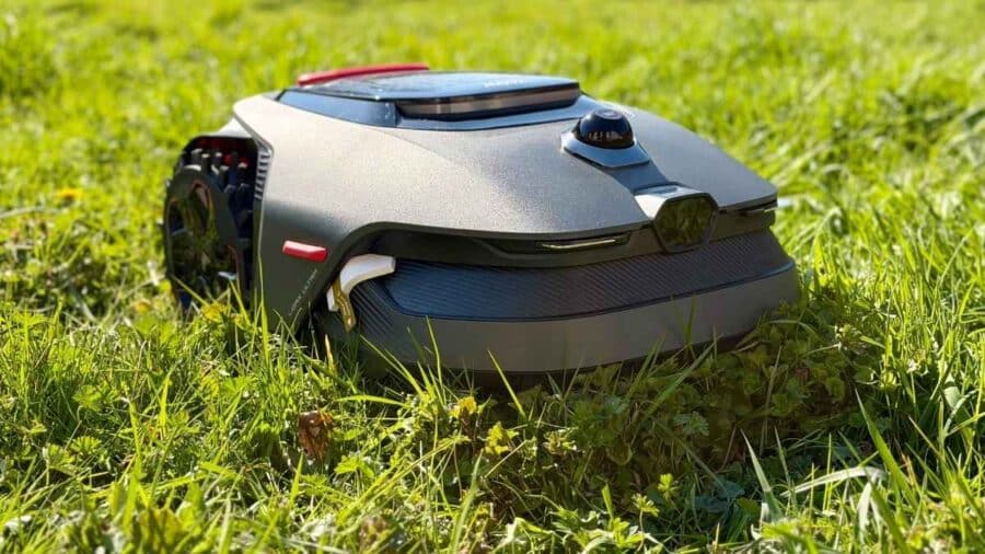 Il robot tagliaerba MOVA LiDAX Ultra 1000 è fermo sull’erba alta in una zona soleggiata del giardino.