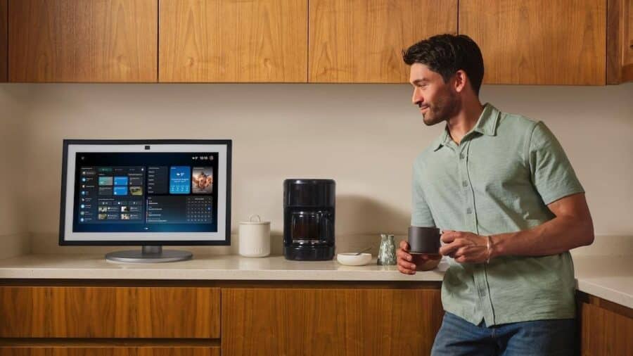 Uomo in cucina che guarda Echo Show 21 con la nuova interfaccia Alexa+ e widget di smart home in italiano