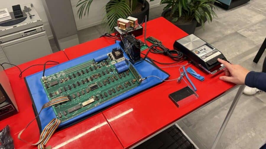 Scheda madre Apple I seriale 002 su tappetino antistatico blu, con alimentatore e registratore a cassette originali
