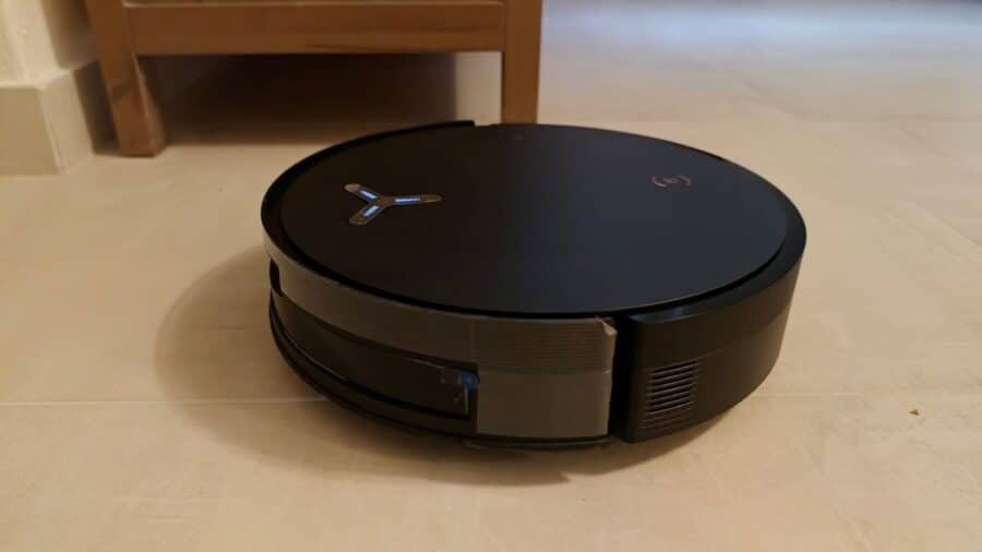 Robot Ecovacs X12 Pro Omni in azione vicino alla gamba di un mobile.