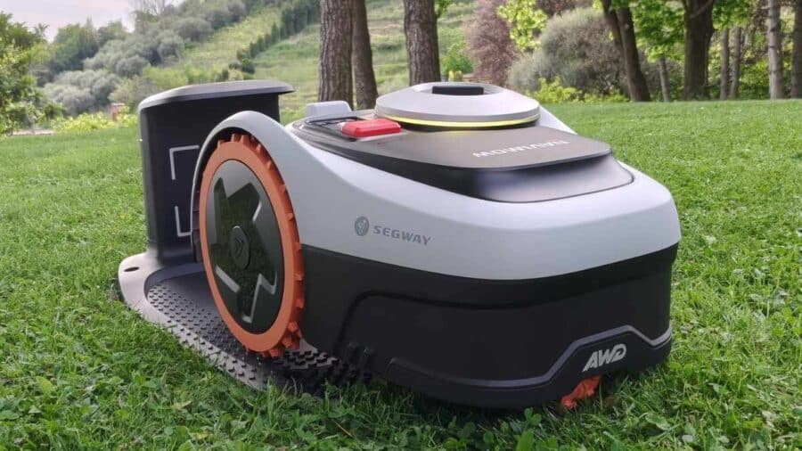 Segway Navimow i206 AWD sulla base di ricarica, prato verde sullo sfondo