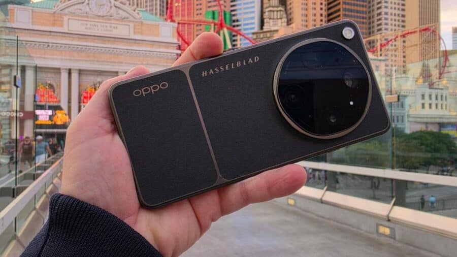 OPPO Find X9 Ultra visto frontalmente con il display e la scritta HASSELBLAD visibile sul retro, tenuto davanti allo skyline di Las Vegas al tramonto