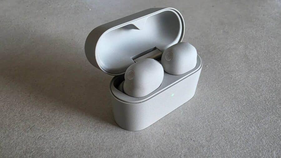 Sony WF-1000XM6 auricolari alloggiati nella custodia aperta con LED verde acceso