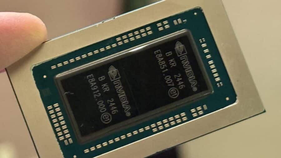 Primo piano di un chip NVIDIA con due die visibili all’interno del package, fotografato mentre viene tenuto tra le dita.