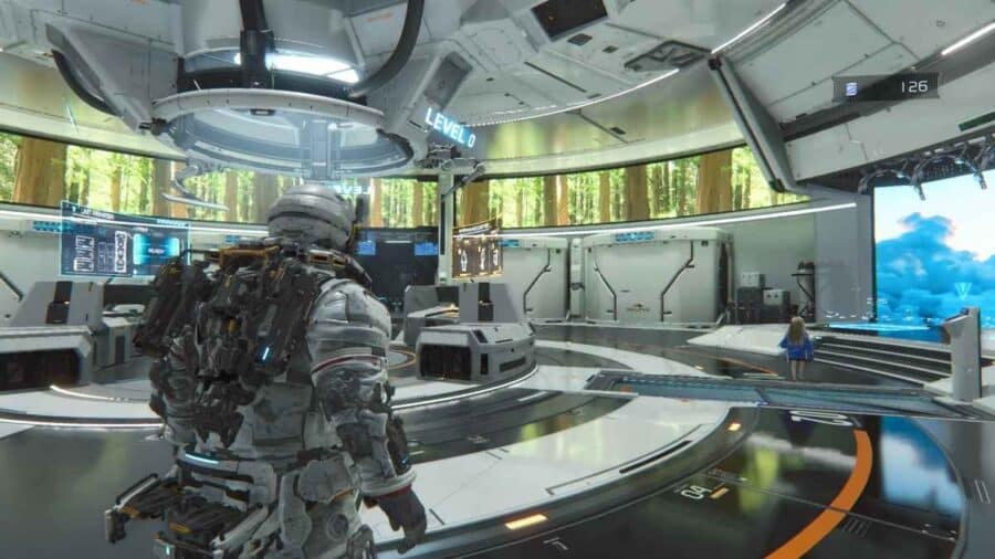 Hugh osserva un grande laboratorio o centro operativo futuristico, con schermi, piattaforme e una grande parete panoramica sullo sfondo.