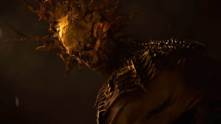 Primo piano di una creatura mostruosa e organica in un’ambientazione oscura, illuminata da una luce calda e inquietante.