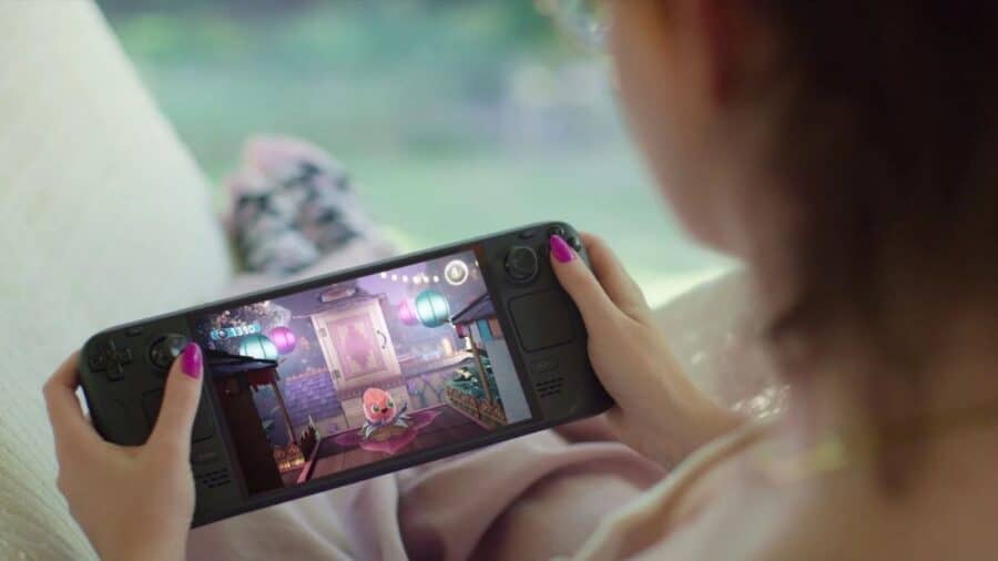 Una persona gioca su Steam Deck tenendo la console portatile tra le mani mentre sullo schermo è visibile un videogioco colorato.
