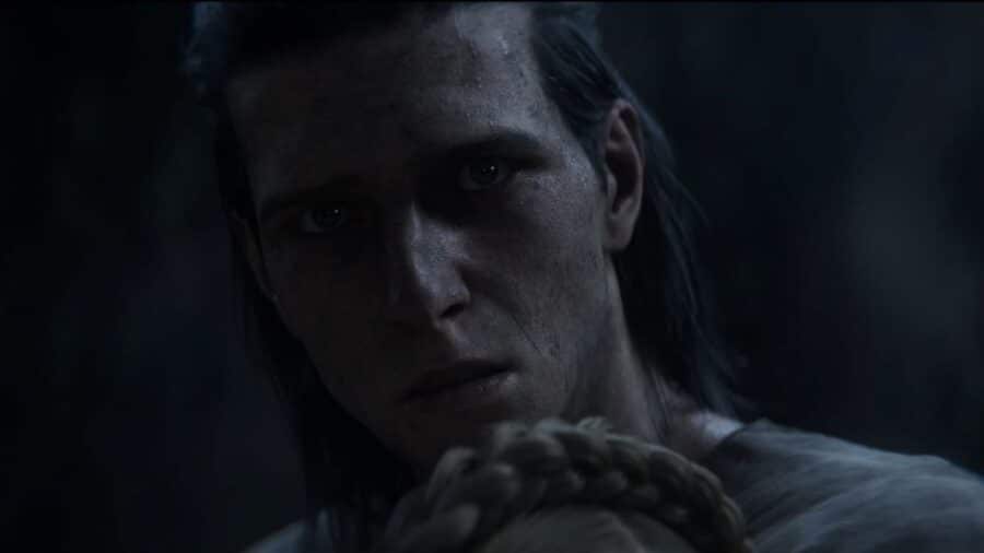Close-up del volto del protagonista di The Blood of Dawnwalker in una scena buia e drammatica, con espressione tesa e intensa.