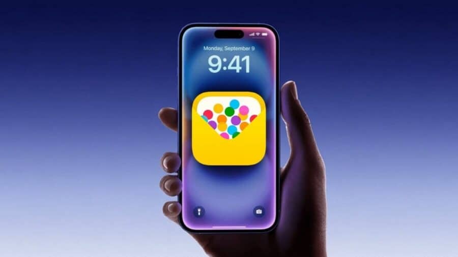 Un iPhone mostra sulla schermata il logo colorato dell’app Inviti Apple, tenuto in mano su sfondo blu sfumato.