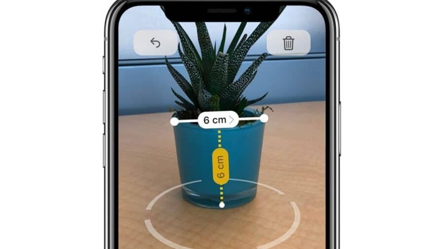 Un iPhone usa l’app Metro per misurare con realtà aumentata un piccolo vaso, mostrando dimensioni di 6 centimetri in larghezza e altezza.