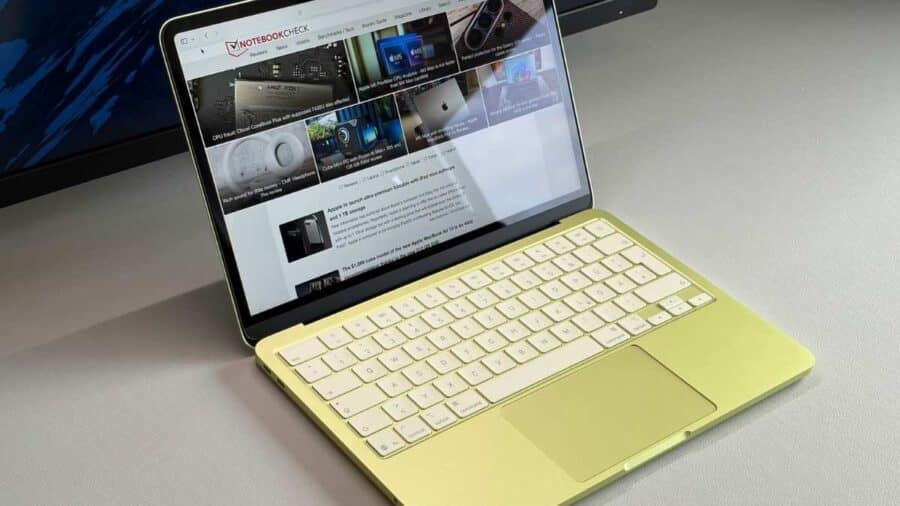 Un MacBook Neo giallo aperto su una scrivania mostra una pagina web sul display, mettendo in evidenza il design compatto del portatile Apple.