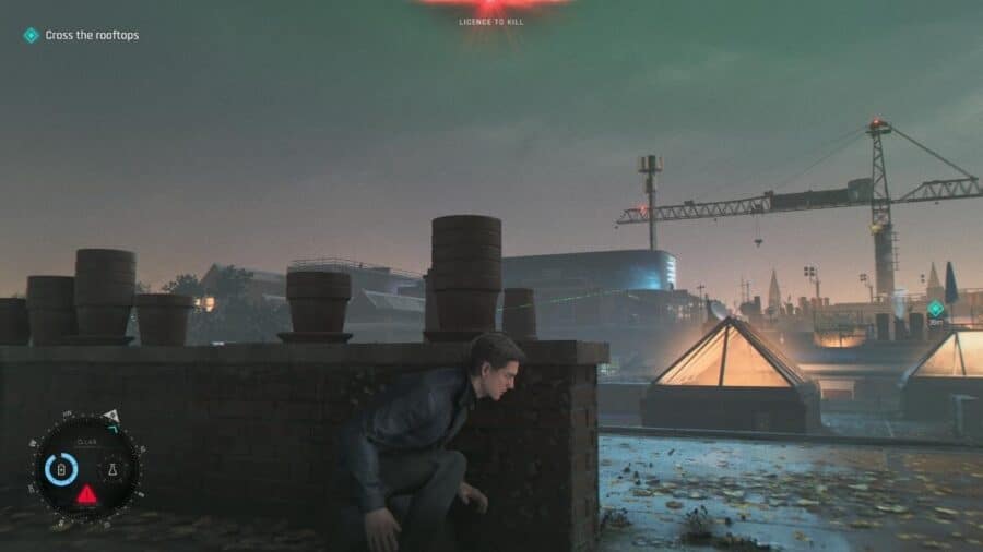 James Bond accovacciato su un tetto durante una missione notturna di 007 First Light, con indicatori dell’interfaccia a schermo.