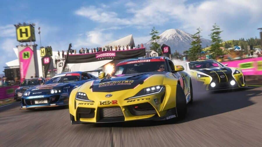 Diverse auto da corsa elaborate affrontano una gara ravvicinata davanti al palco del festival Horizon, con una Toyota Supra gialla in primo piano e il Monte Fuji sullo sfondo.