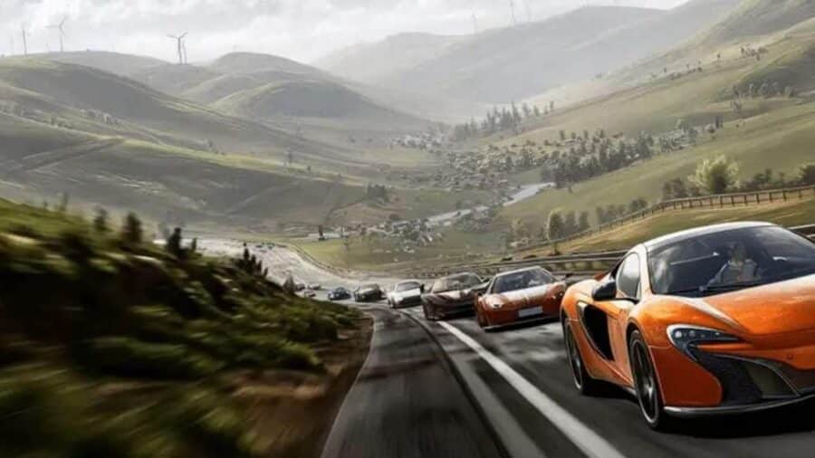 Convoglio di supercar lanciato su una strada panoramica tra colline verdi, con una McLaren arancione in primo piano e vallate sullo sfondo.