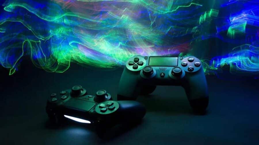 Due controller PlayStation illuminati da scie luminose blu e verdi, immagine simbolica del gaming moderno e dei servizi digitali.