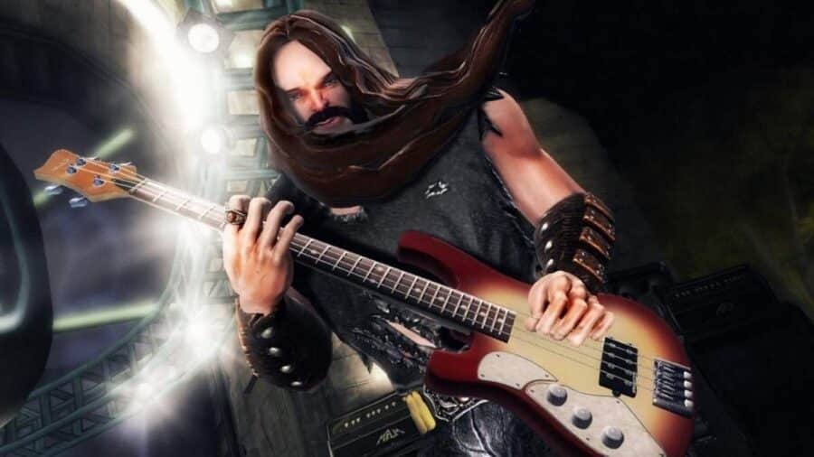 Personaggio di Guitar Hero mentre suona un basso elettrico su un palco illuminato, con look rock e atmosfera da concerto virtuale.