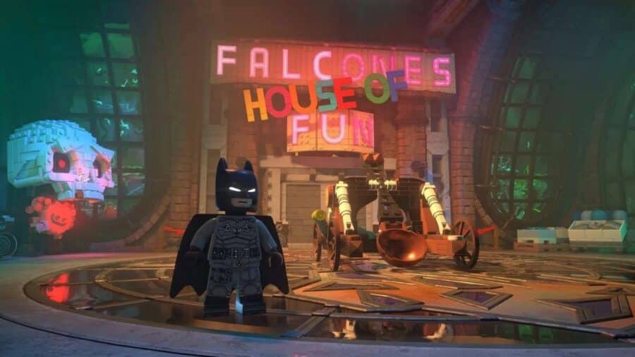 Batman davanti alla Funhouse del Joker in LEGO Batman L’Eredità del Cavaliere Oscuro, con insegne al neon, scenografie colorate e atmosfera da luna park criminale.