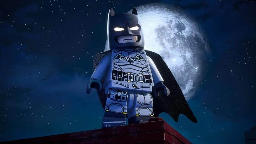 Primo piano di Batman in versione LEGO davanti alla luna piena, con mantello nero e costume grigio ispirato al Cavaliere Oscuro.