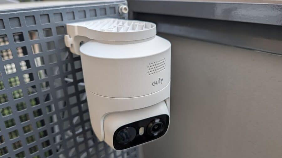 eufyCam C37 eufy Security vista a tre quarti, con doppio obiettivo e spotlight visibili, montata su superficie grigia esterna