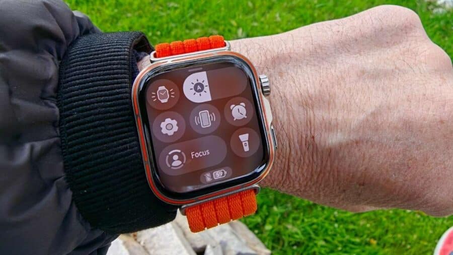 Huawei Watch Fit 5 Pro indossato al polso con centro di controllo attivo e cinturino arancione, all'aperto
