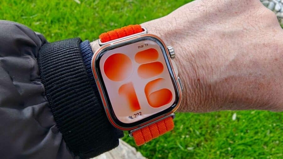 Huawei Watch Fit 5 Pro al polso con quadrante personalizzato in tonalità arancio e forme astratte
