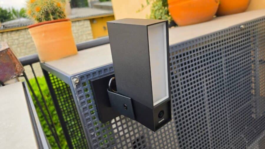 Netatmo Videocamera Esterna Original installata su ringhiera di balcone con faretto LED spento, vista frontale laterale