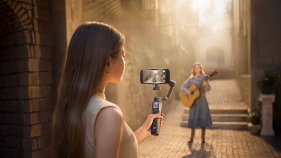 Una ragazza usa Osmo Mobile 8P per riprendere una persona che suona la chitarra