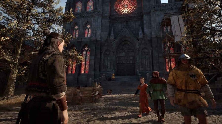 Coen osserva l’ingresso di una grande cattedrale gotica illuminata da vetrate rosse, mentre alcuni abitanti camminano nella piazza di un villaggio medievale in The Blood of Dawnwalker.