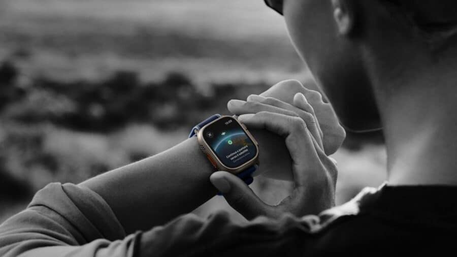 Persona all’aperto osserva lo schermo di un Apple Watch Ultra al polso, con interfaccia dedicata ad attività e monitoraggio.