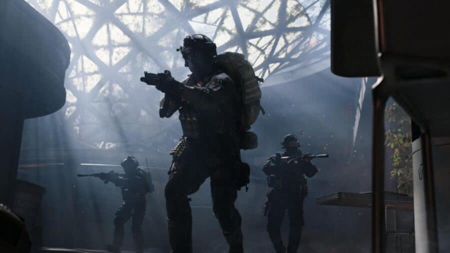 Soldati di Call of Duty Modern Warfare 4 avanzano con armi spianate in un edificio illuminato da fasci di luce e atmosfera fumosa.