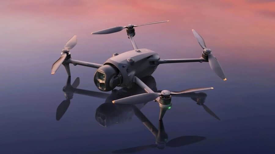 DJI Mavic 4 Pro appoggiato su una superficie riflettente al tramonto, con bracci aperti e fotocamera frontale.